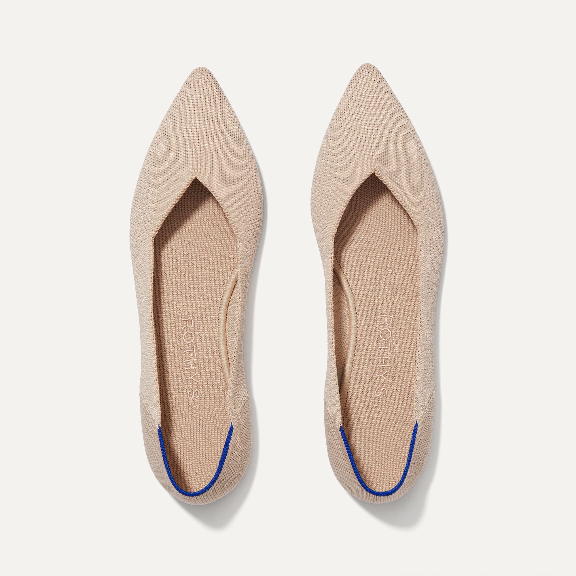 A pair of The Point shoe in Ecru shown from the top view.