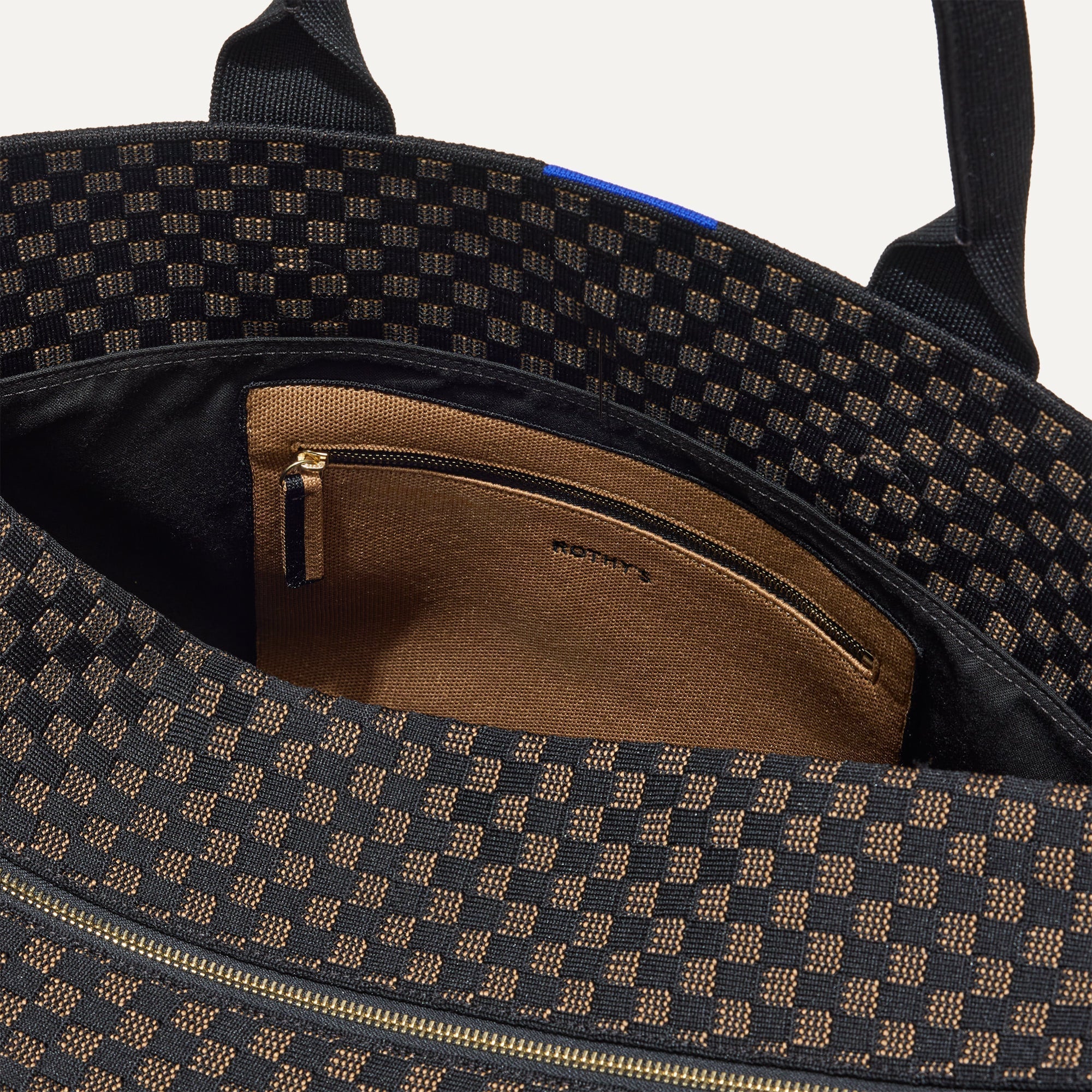 The Weekender in Night Song shown with a close up view of the interior zipper pocket in the magnetic side compartment. 