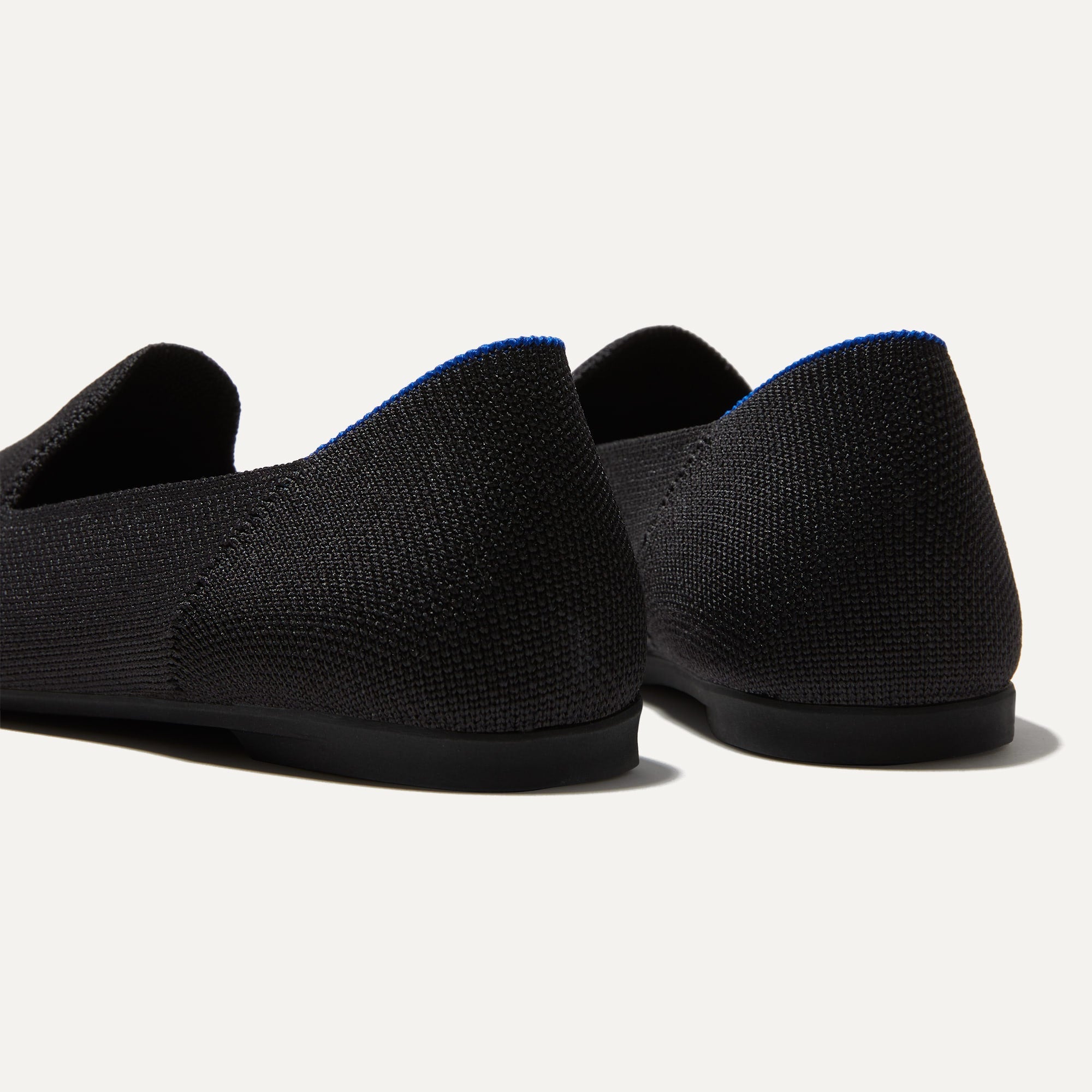 Close up of the heel of The Almond Loafer in Black, with Rothy's signature blue halo. 