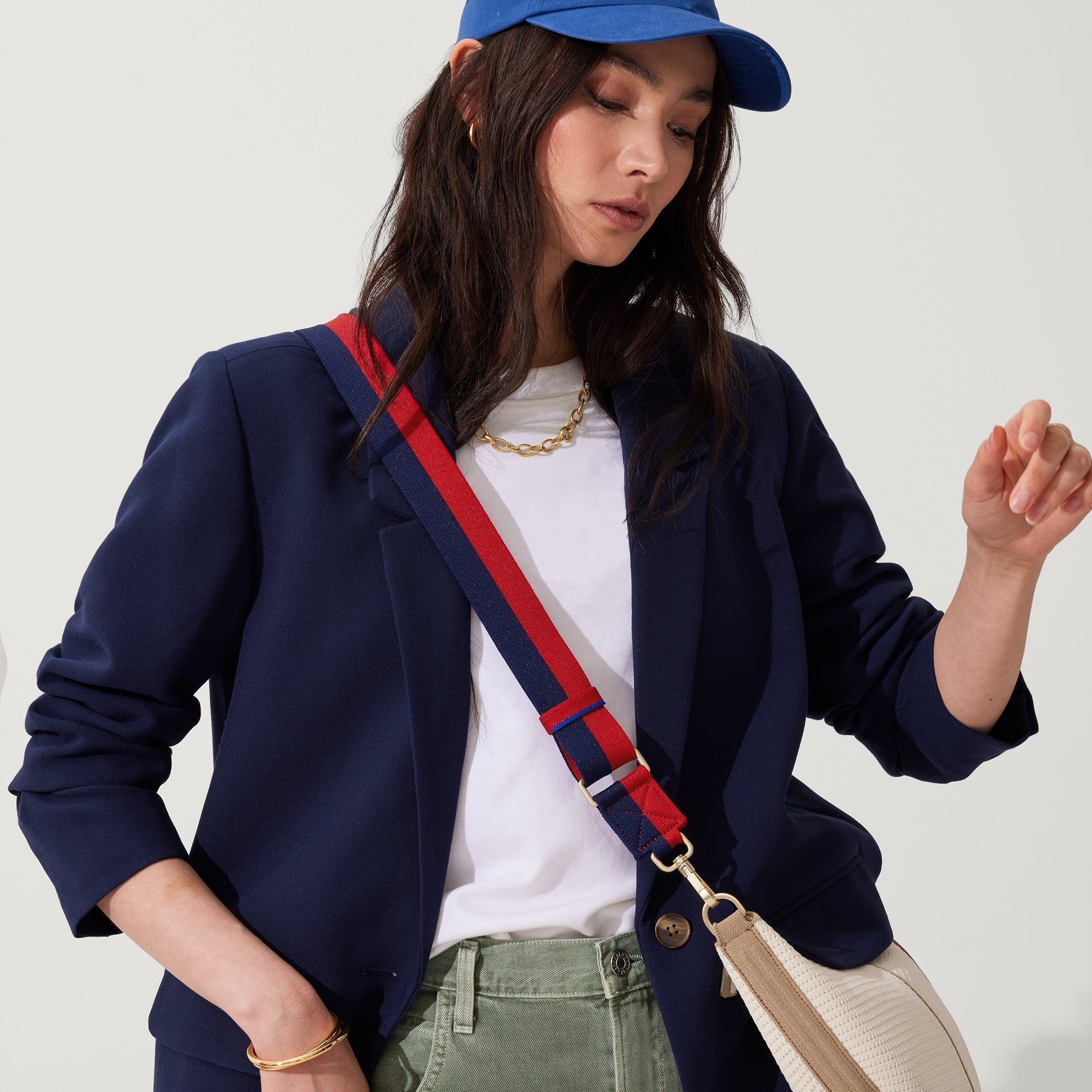 hover | The Crossbody Strap in Navy & Red, shown paired with The Crescent Bag, worn by a model, shown from the side