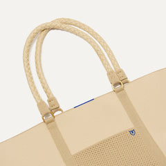 A close up of The Summer Tote in Meringue focusing on the pocket and handles.