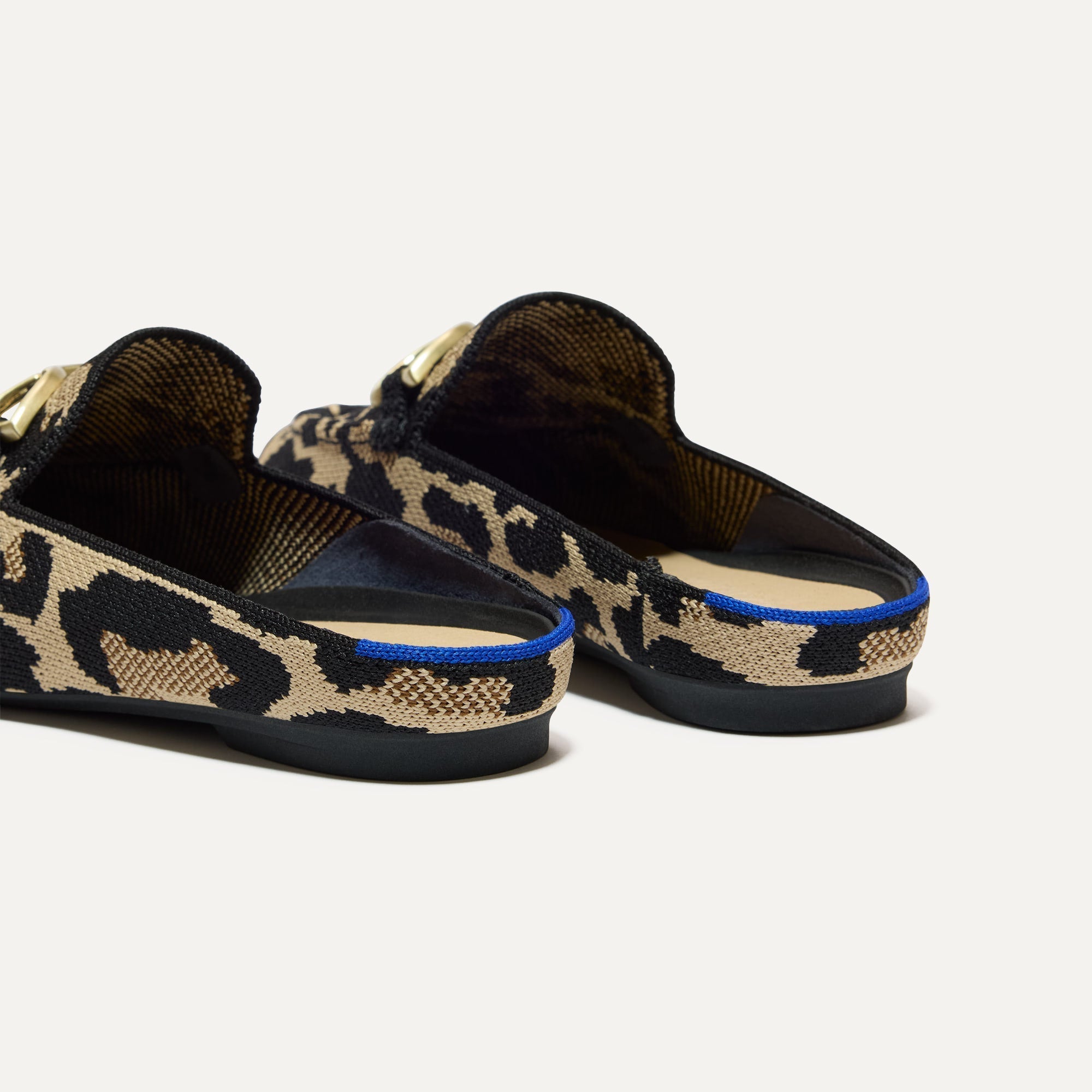 Close up of the heel of The Double Bit Loafer Mule in Desert Cat, with Rothy's signature blue halo. 