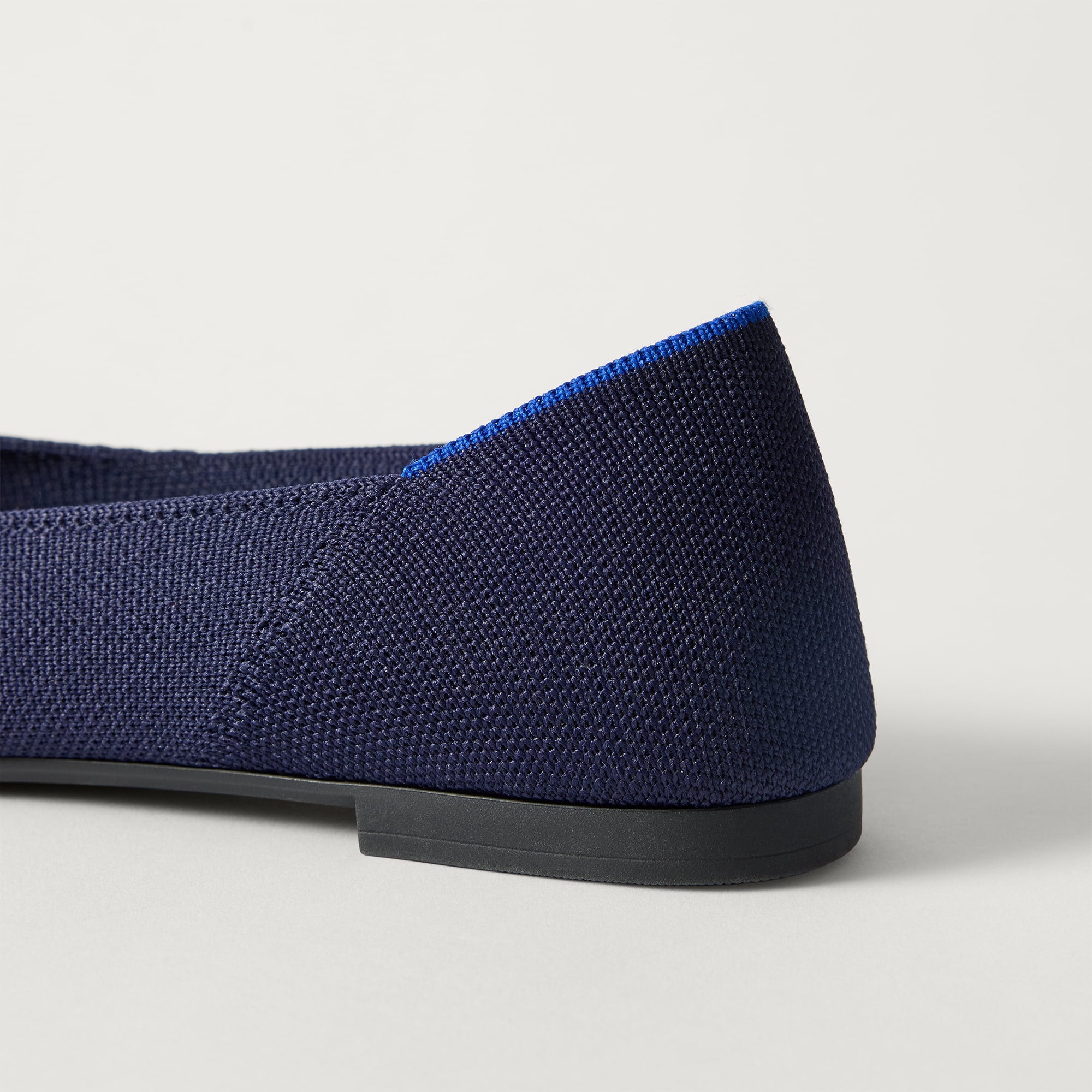 Close up of the heel of The Point III in Navy, with Rothy's signature blue halo. 